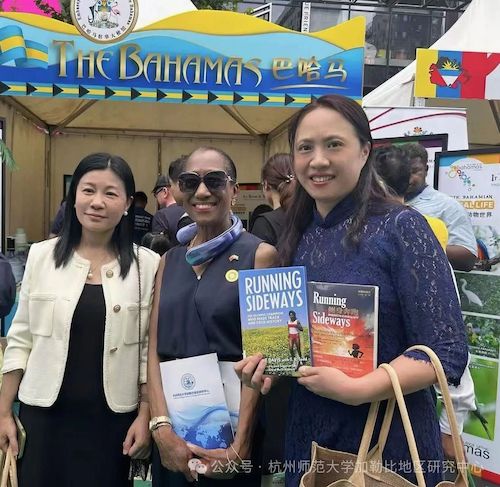 图二 2025年6月15日，王剑晖老师在第三届加勒比文化体验日活动中向巴哈马驻华大使波莱特·贝瑟尔阁下介绍加勒比地区研究中心，并向她赠送自己翻译的巴哈马奥运冠军波琳·戴维斯的传记